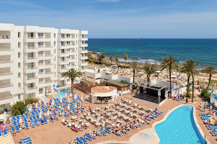 Hotelanlage mit mehreren Pools, Liegestuhlreihen, Palmen und Blick auf das Meer. Hotelanlage mit mehreren Pools, Liegestuhlreihen, Palmen und Blick auf das Meer.