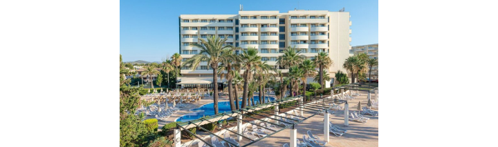 Ein Hotel umgeben von Palmen mit einem einladenden Swimmingpool im Vordergrund