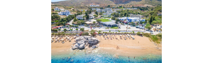 Strand und Resort in Kreta mit Blick auf das Hotel in Rhodos, umgeben von klarem Wasser und sonnigem Himmel.