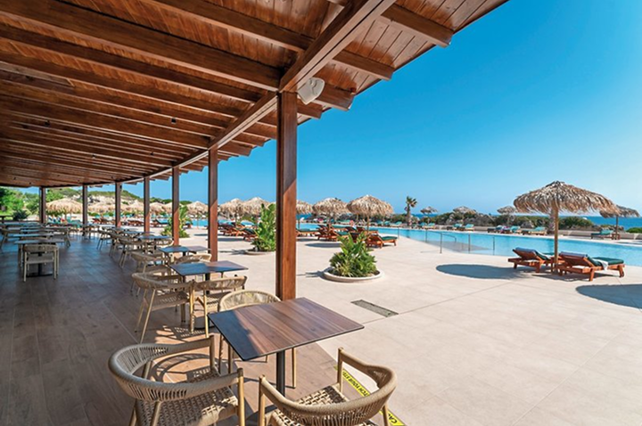 Panoramaansicht des Pools und des Strandes in einem eleganten Luxushotel, ideal für Entspannung und Erholung.
