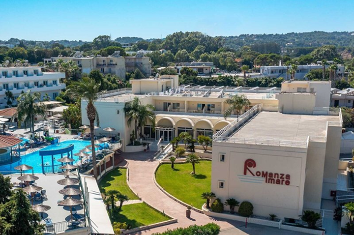 Großer Swimmingpool mit mehreren Palmen und strohgedeckten Pavillons vor einem weißen Hotelgebäude. Großer Swimmingpool mit mehreren Palmen und strohgedeckten Pavillons vor einem weißen Hotelgebäude.