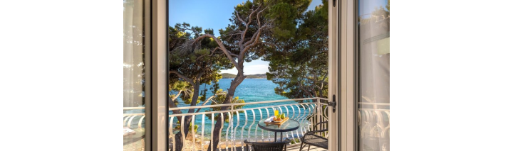 Blick auf das Meer durch ein Fenster in einem Hotel in Kroatien, das die entspannende Atmosphäre der Küste einfängt.